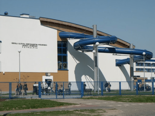 Budynek szkoły z niebieskimi rurami.